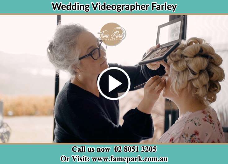 A woman applying makeup to the Bride Farley NSW 2320