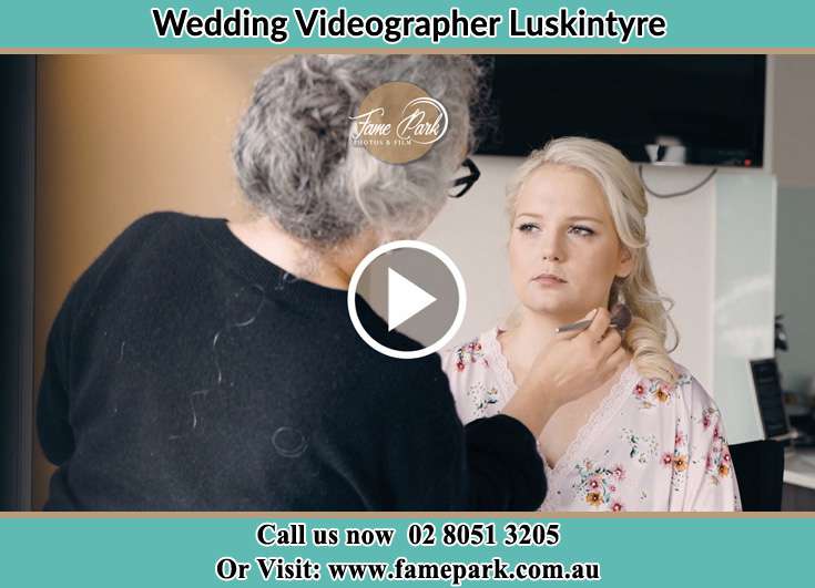 A woman applying makeup to the Bride Luskintyre NSW 2321