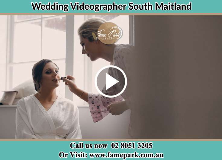 A woman applying lipstick to the Bride South Maitland NSW 2320